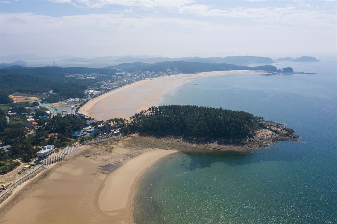 태안 소원면 만리포 해변과 그 뒤로 이어진 마을, 숙박시설, 솔숲을 내려다본 항공 사진